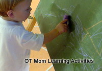 toddler scribbling on blackboard