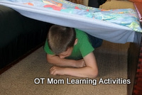 child doing a leopard crawl through an obstacle course
