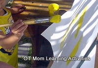 Preschool child painting with right hand holding a brush