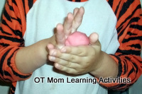 preschool child rolling a ball of playdough with the hands