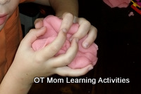preschool child squashing playdough into a blob ball