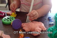 toddler making impressions in playdough with fork