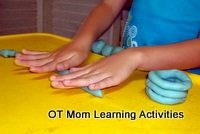rolling sausages of playdough with both hands to help bilateral coordination